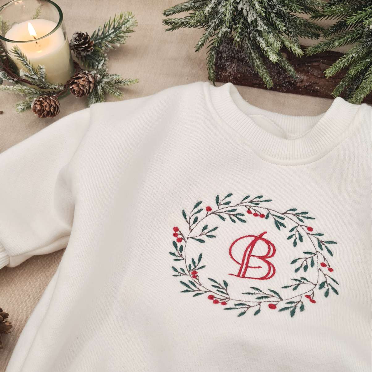 Detailed view of the embroidered monogrammed initial and Christmas wreath on the Romper.