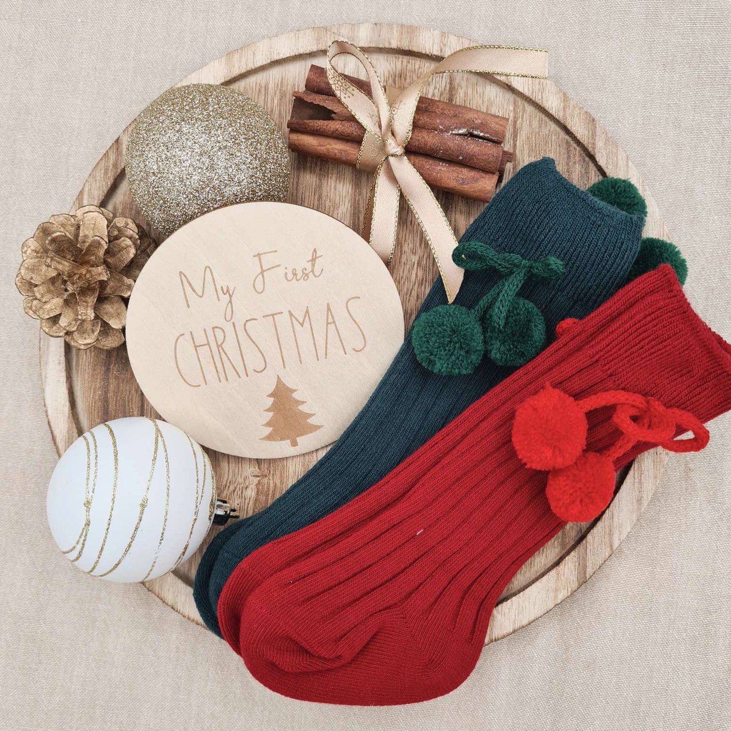 Untreated natural wood 'First Christmas' milestone sign with the Reindeer Baby Romper.