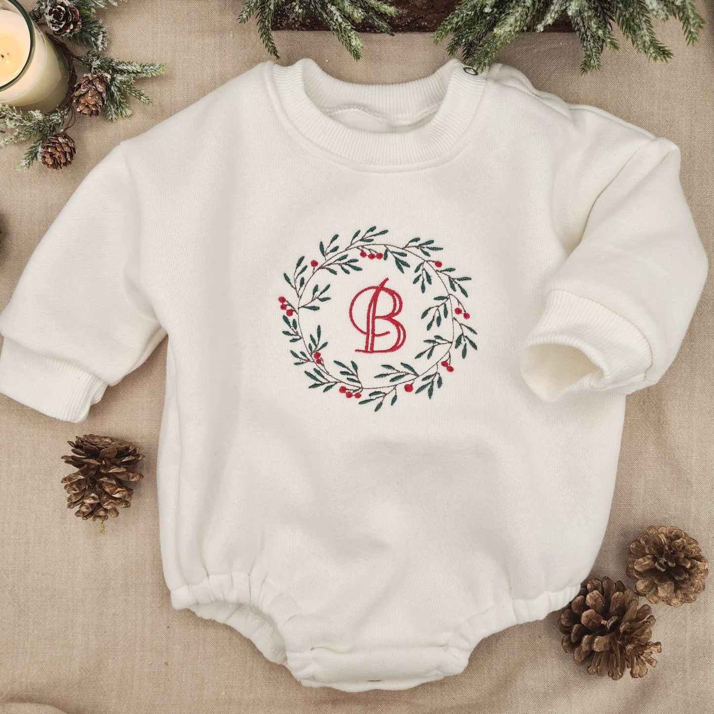 Overall view of the off-white Baby Romper with Christmas wreath and monogrammed design.
