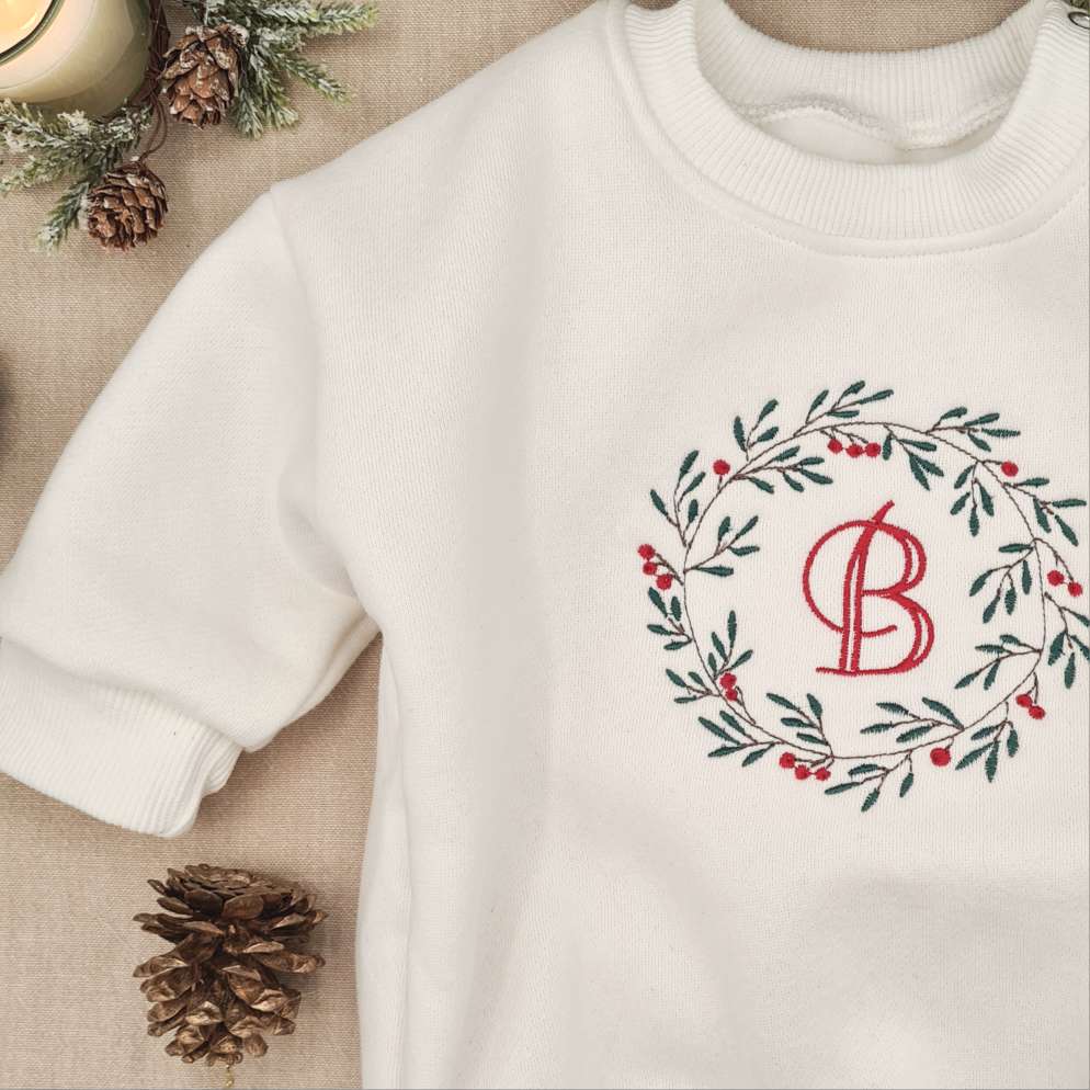 Side angle of the Baby Romper showing the premium fleece material and wreath design.