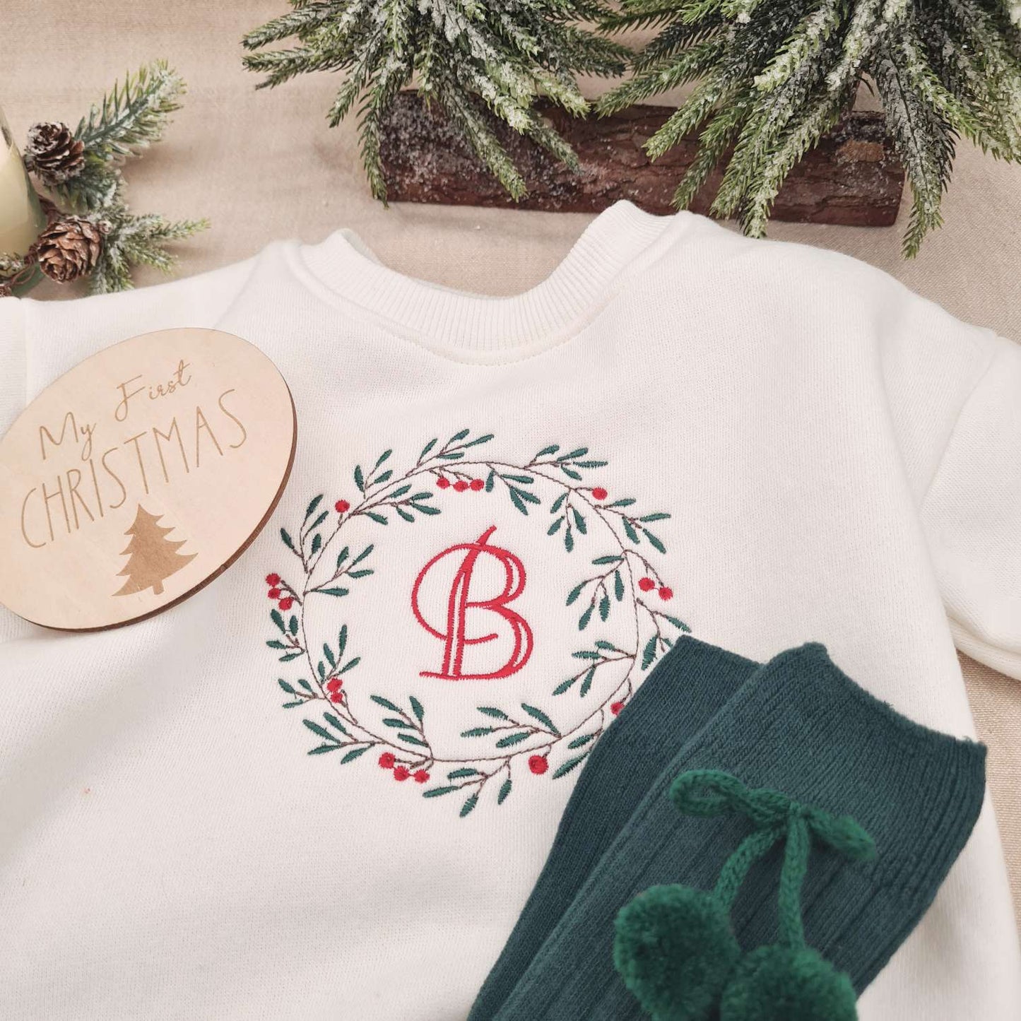 Natural wood 'First Christmas' milestone sign alongside the Monogrammed Baby Romper.