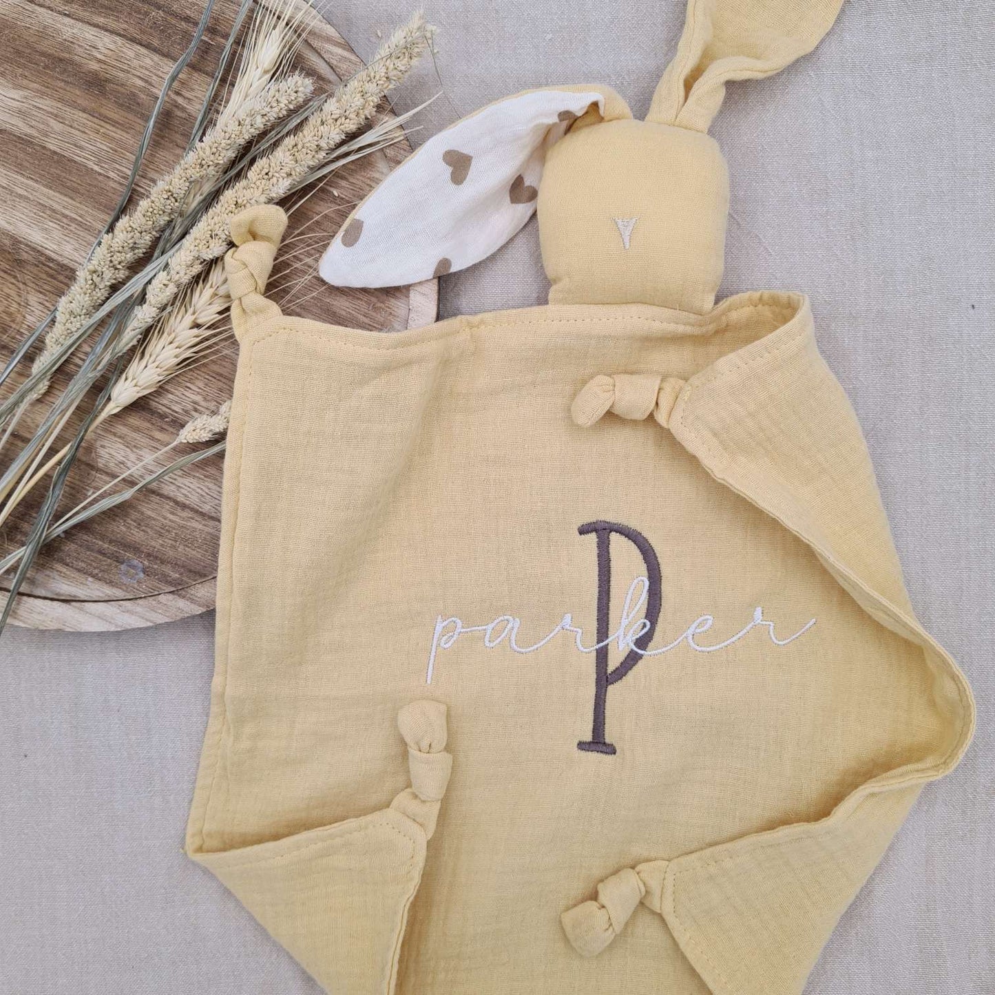 Personalised yellow baby comforter with bunny ears, embroidered with name 'Parker'. Soft cotton fabric, ideal for soothing babies.