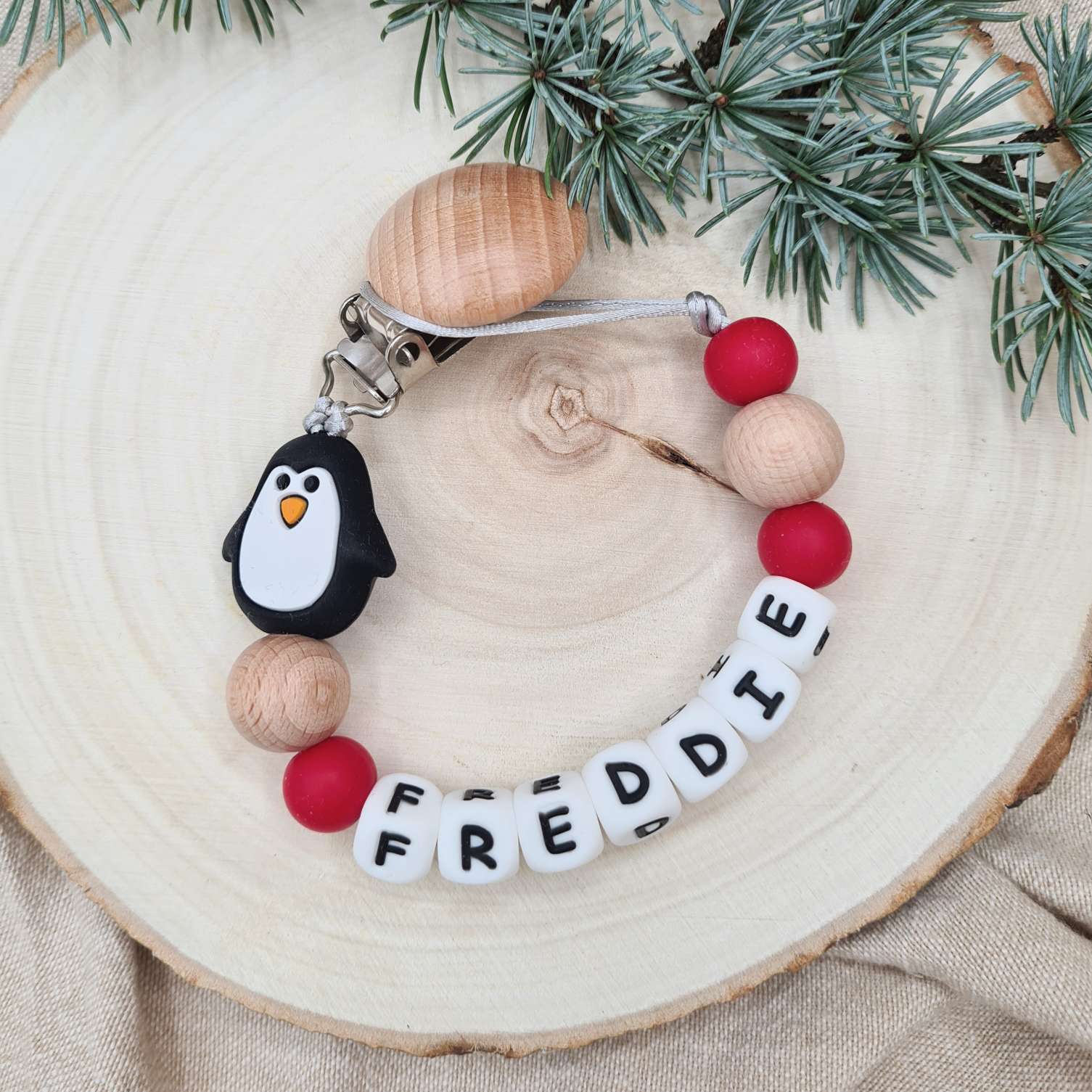 Personalised dummy clip with Christmas penguin bead and festive colours.