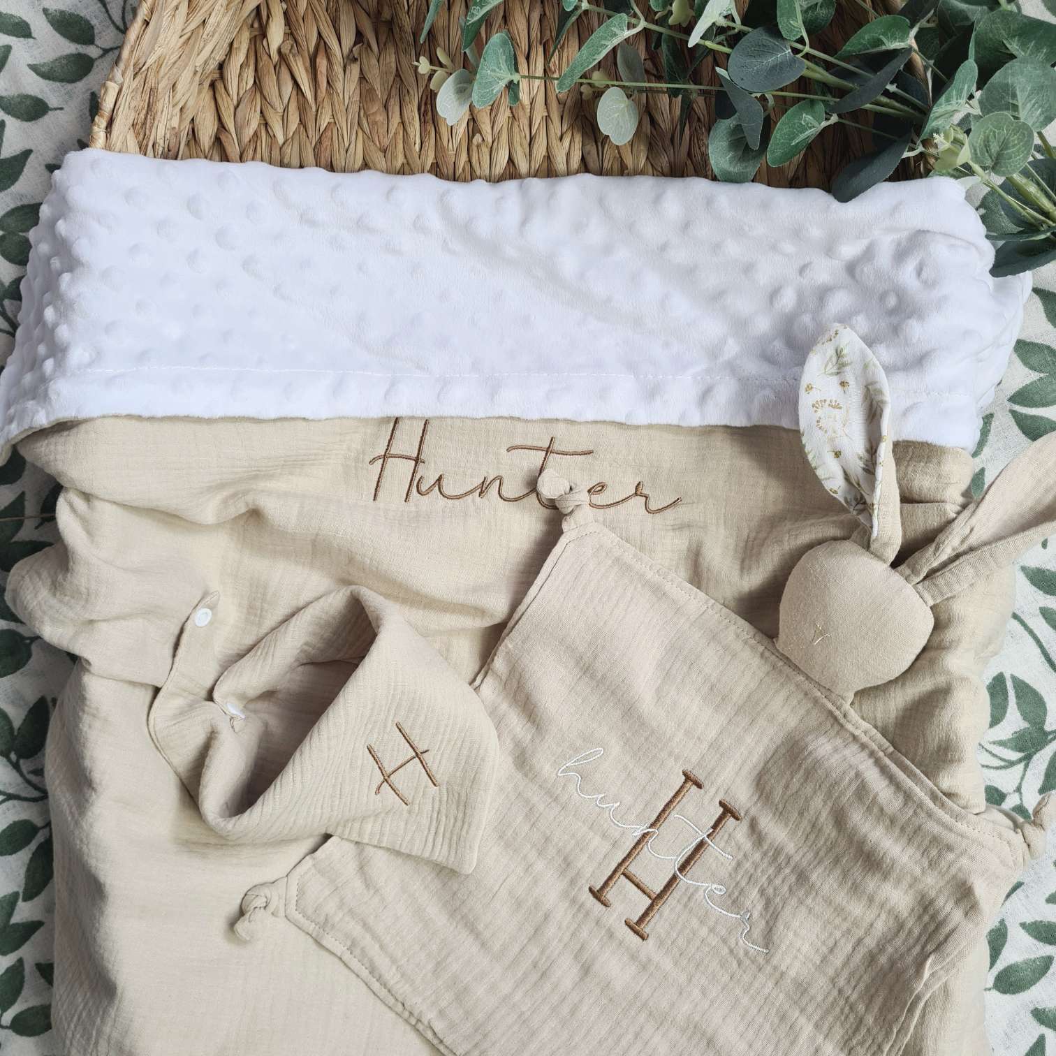 Personalised baby blanket gift set in beige, with embroidered name 'Hunter'. Comes with a blanket, bunny comforter, and bib, all made from organic muslin.