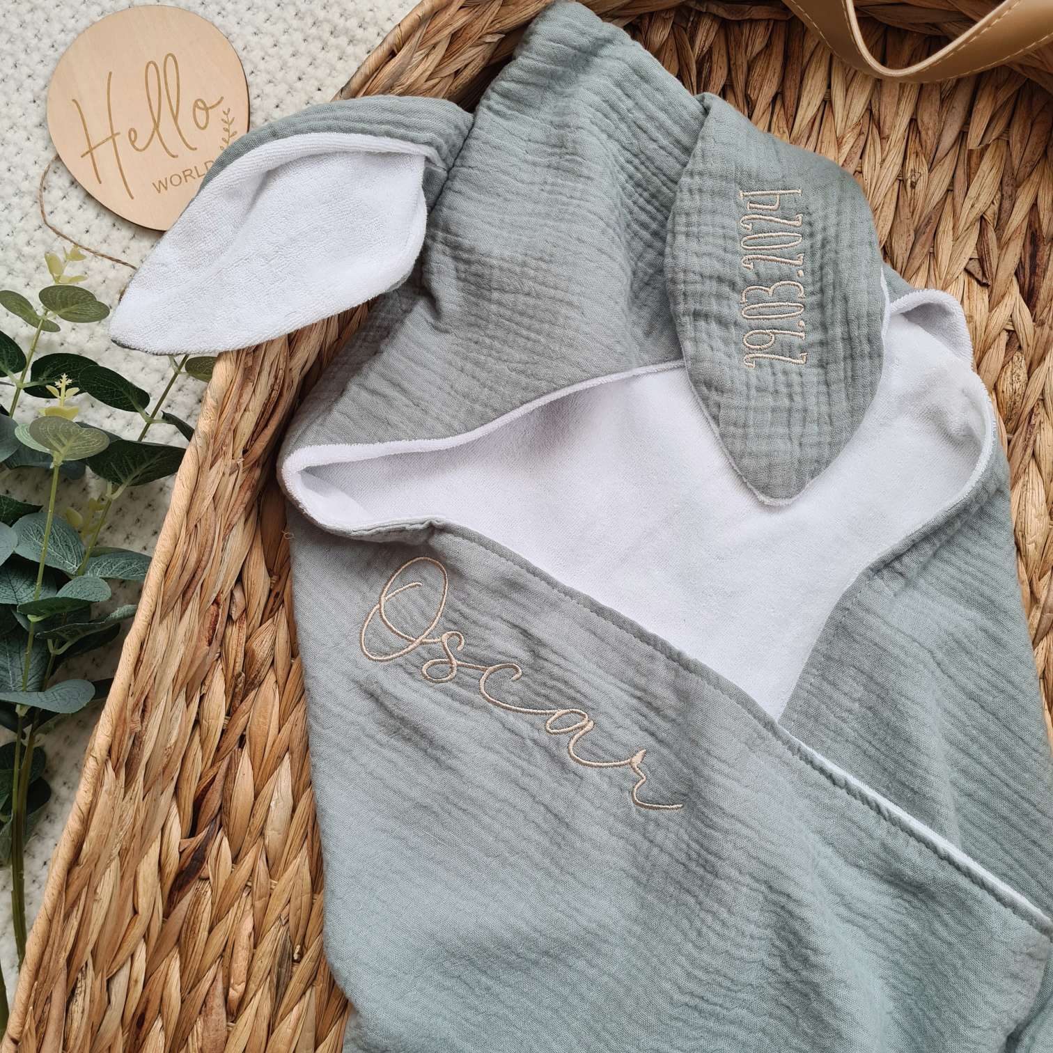 Personalised hooded baby towel with embroidered name 'Oscar' and bunny ears. Made from soft organic cotton muslin and terry, perfect for newborns.